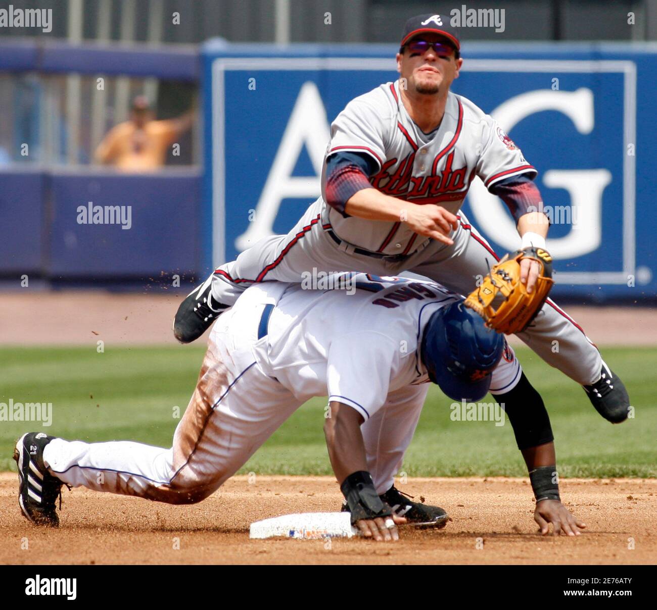 New York Mets runner Carlos Degado (bottom) tries to upend Atlanta Braves second baseman Marcus Giles and break up a double play in the first inning of their MLB game in New York, May 6, 2006. Mets batter David Wright was out at first base. REUTERS/Ray Stubblebine Stock Photo