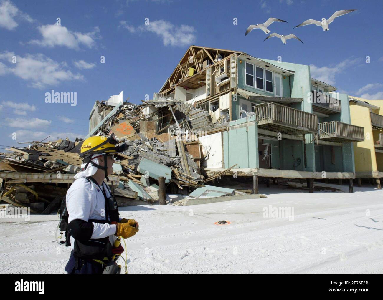 Juan Baquero of Central Florida Urban Search and Rescue Task Force 4 stands in front of a building, which was damaged by Hurricane Ivan, in Naverre Beach, Florida in this September 17, 2004, file photo. Florida's big push to slash homeowner insurance premiums, a major issue in a state hurt by a sinking real estate market, has turned to bust in the face of stiff opposition from the powerful property-insurance industry. Picture taken September 17, 2004. REUTERS/Rick Wilking /File  (UNITED STATES) Stock Photo