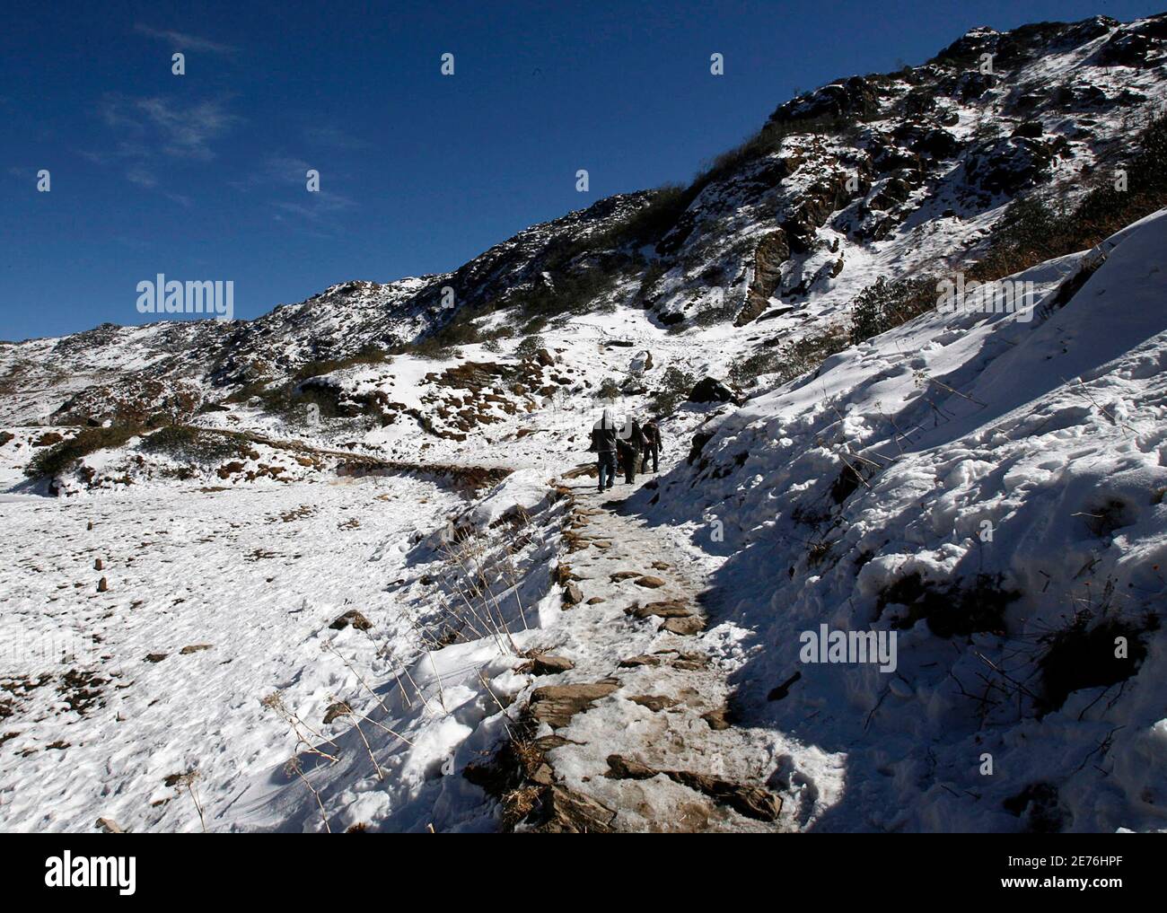 Tourists walk amid the snow after a snowfall near Nathu-La, 55 km (34 miles) north of Gangtok, capital of India's northeastern state of Sikkim, January 17, 2009. The Nathu-La mountain pass, known as the old silk route, lies at an altitude of 14,200 ft. bordering between India and China and is covered with snow throughout the year. Picture taken January 17, 2009. REUTERS/Rupak De Chowdhuri (INDIA) Stock Photo