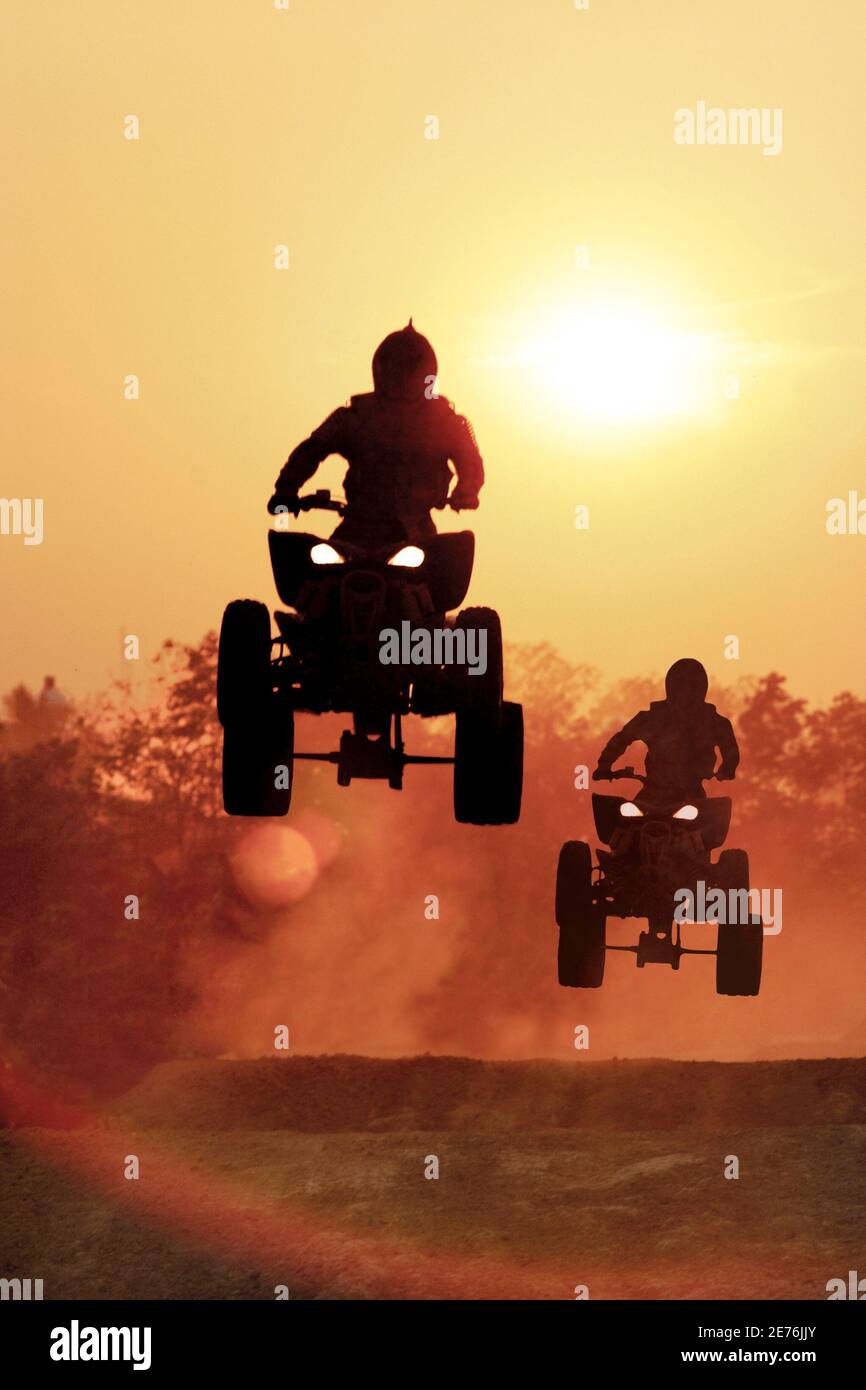 Silhouette ATV jump on dirt tract Stock Photo