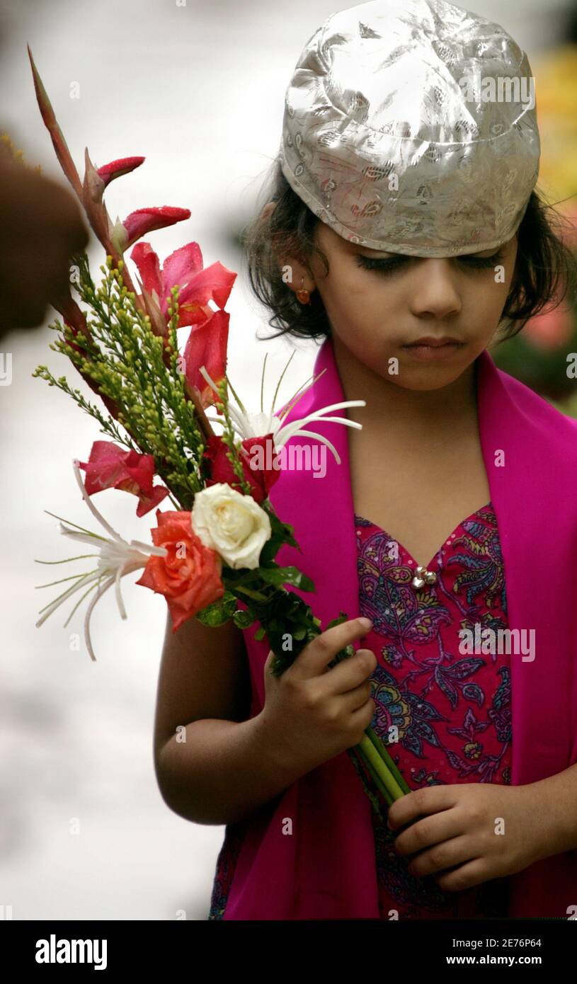 A girl holds flowers at a Parsi temple on the Parsi New Year in Mumbai August 20, 2005. Followers of the Persian prophet Zarathustra, the Parsi community arrived in western India 1200 years ago after they fled Persia following persecution from Arab conquerors. Stock Photo