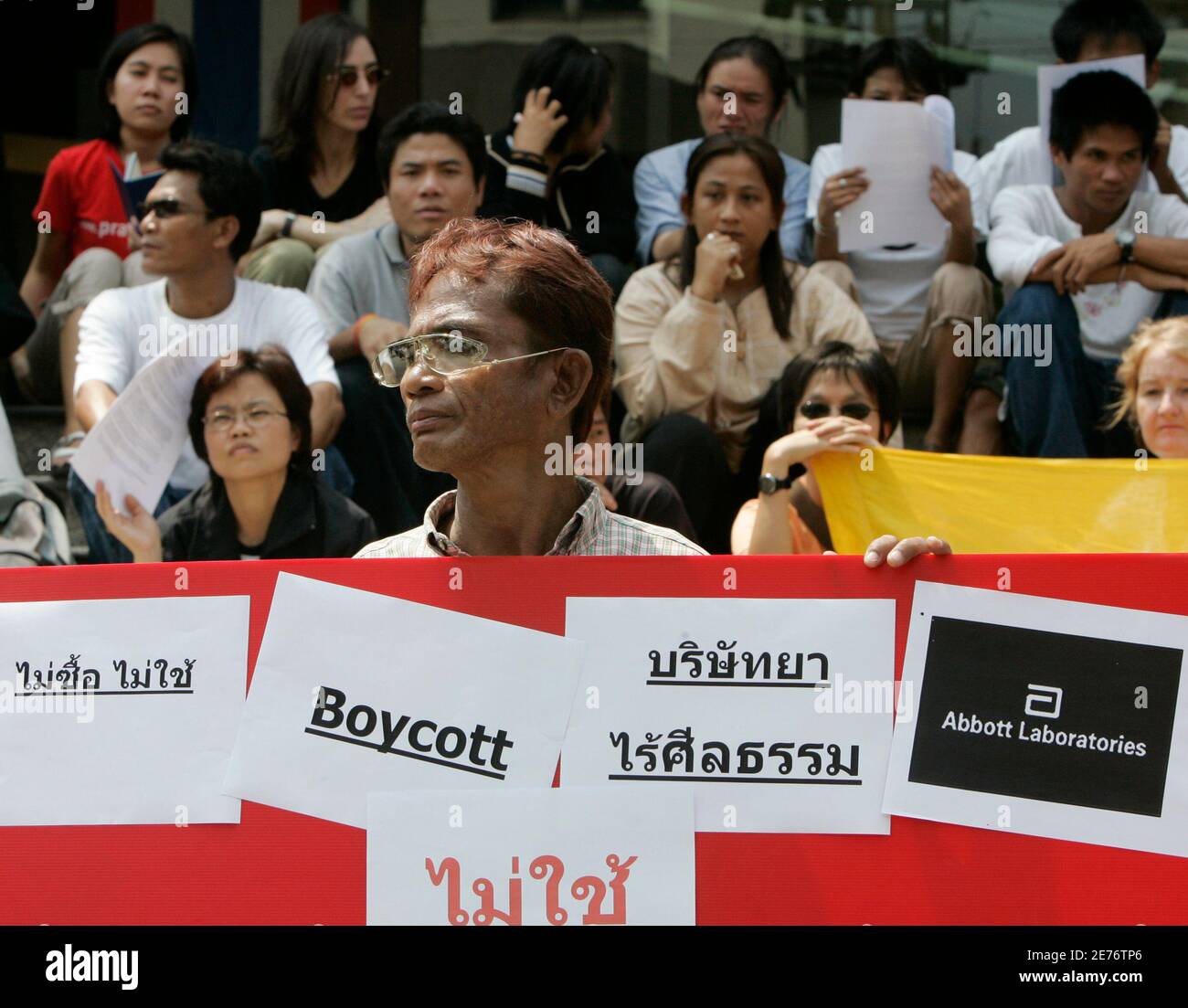An HIV-infected Thai protester carries a banner condemning U.S. giant Abbott Laboratories' for withdrawing sales of new drugs in Thailand, in front of Abbott's Bangkok office March 14, 2007. Abbott Laboratories said it would stop launching new medicines in Thailand in protest at the army-backed government's move to override international drug patents.  REUTERS/Chaiwat Subprasom  (THAILAND) Stock Photo