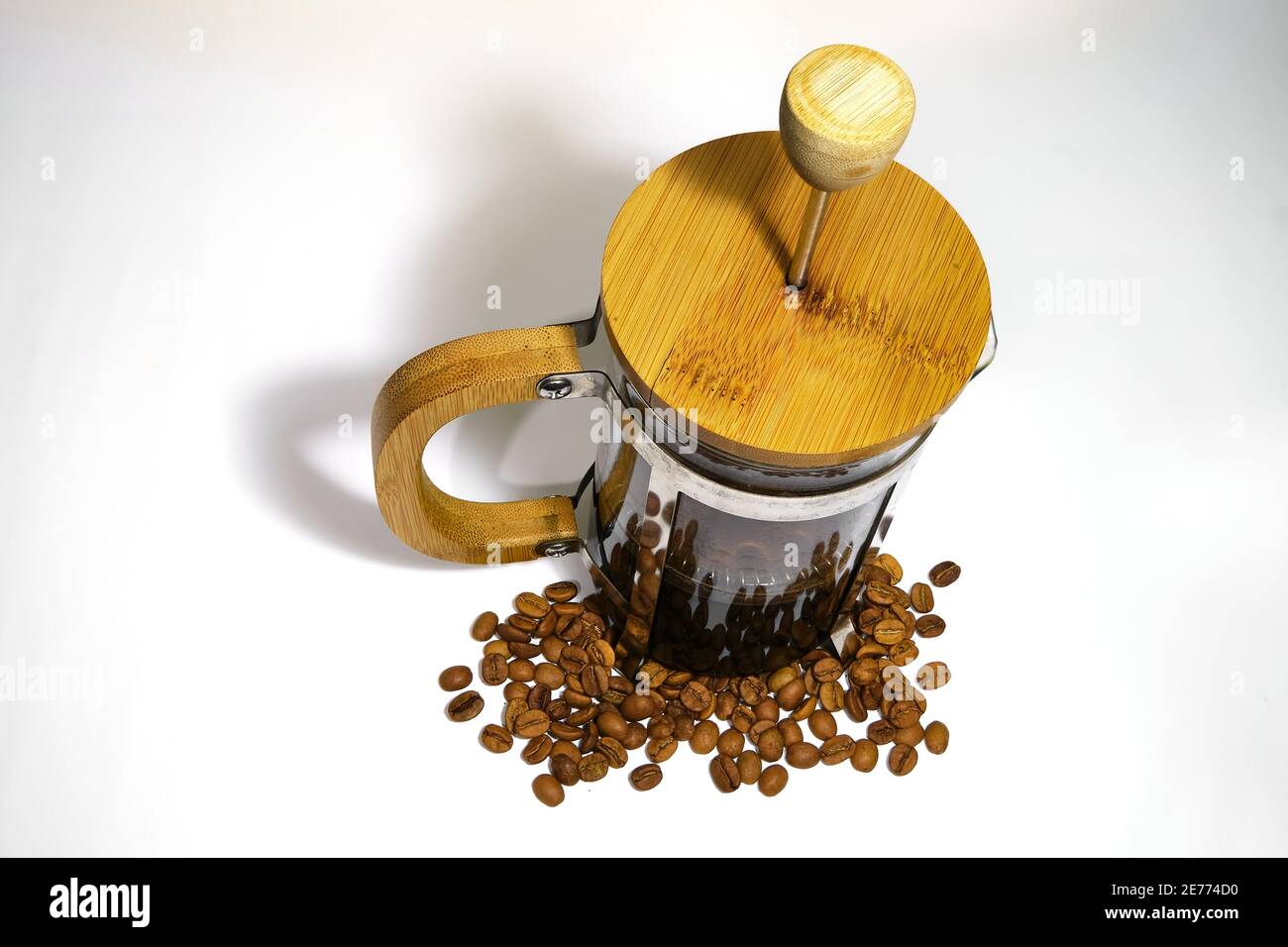 French press coffee maker on the white ground. Arabic coffee beans bottom  of the french press and cooked caffe inside the glass side of the press  Stock Photo - Alamy