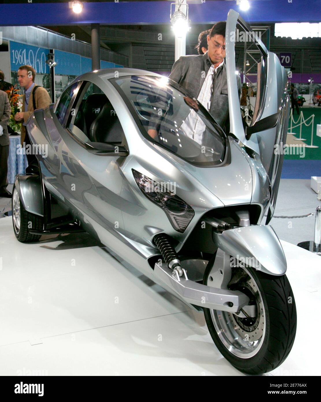 A visitor gets into Phiaro Group's prototype two-seater three-wheel vehicle  "P67b ETERNITY" at the Tokyo Motor Show at Makuhari Messe in Chiba, east of  Tokyo October 20, 2005. Dozens of concept cars