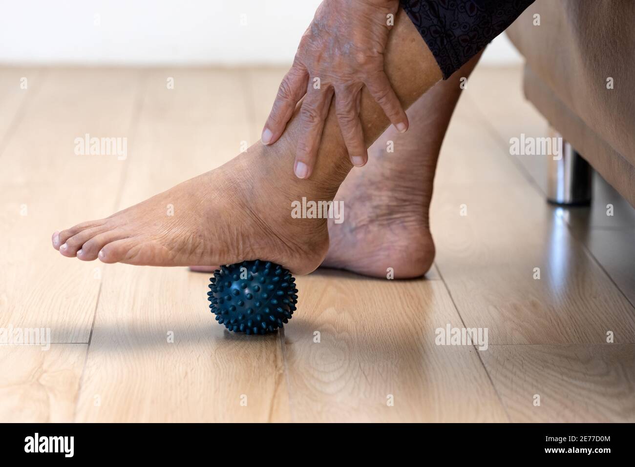Elderly woman doing rubber ball for exercise fingers, palm ,hand and foot muscle with caregiver take care. Stock Photo