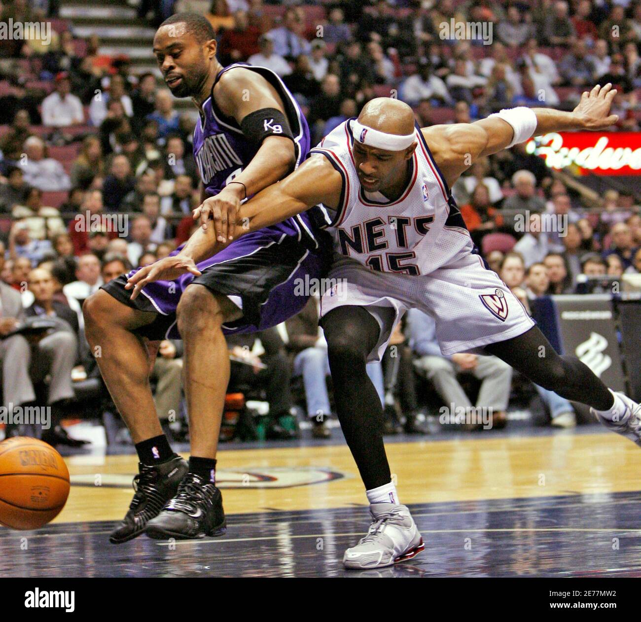 Sacramento Kings forward Kenny Thomas (L) reacts as New Jersey Nets guard Vince  Carter (15) tries to steal the ball in the third quarter of their NBA game  in East Rutherford, New
