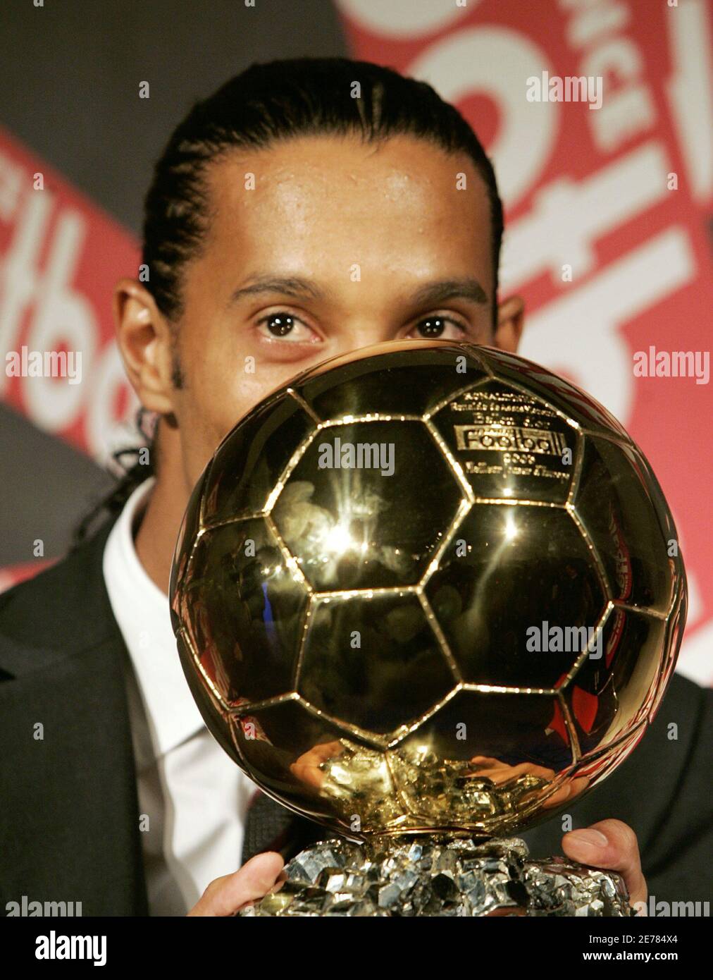 Brazilian soccer star Ronaldinho peers above his Ballon d'Or (Golden Ball)  award as European Footballer of the Year during a press conference in Paris  November 28, 2005. Ronaldinho won the award, celebrating