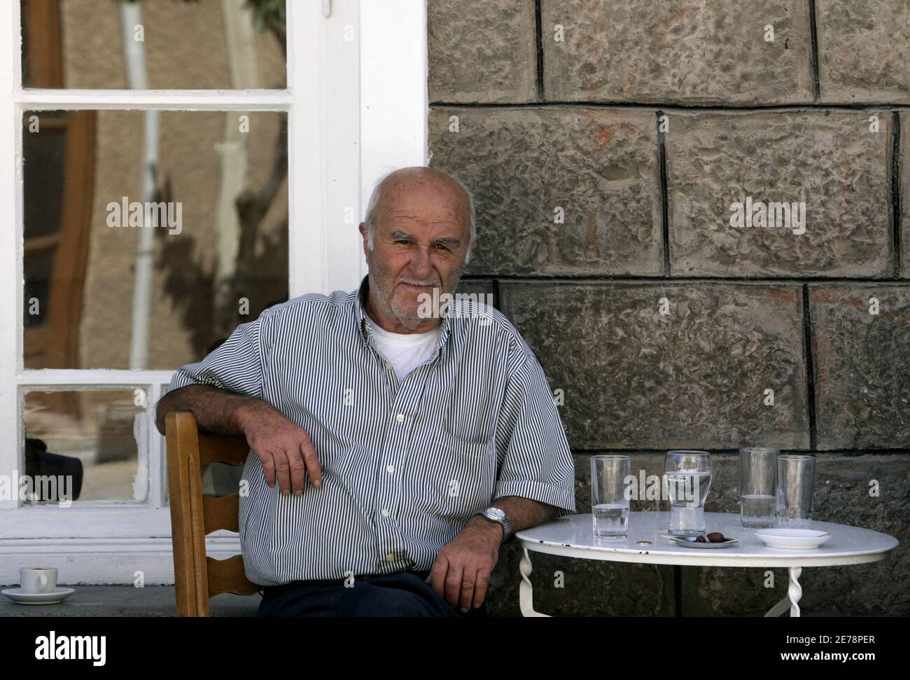 Retired sailor Christos Labropoulos, 71, sits at a coffee shop in the town of Kirra in central Greece, some 200km (124 miles) west of Athens, September 11, 2007. Days before a closely fought Greek election, a deep political divide has gripped the town of Kirra, which correctly predicted the result of the last parliamentary vote. Picture taken September 11, 2007. REUTERS/Yiorgos Karahalis  (GREECE) Stock Photo