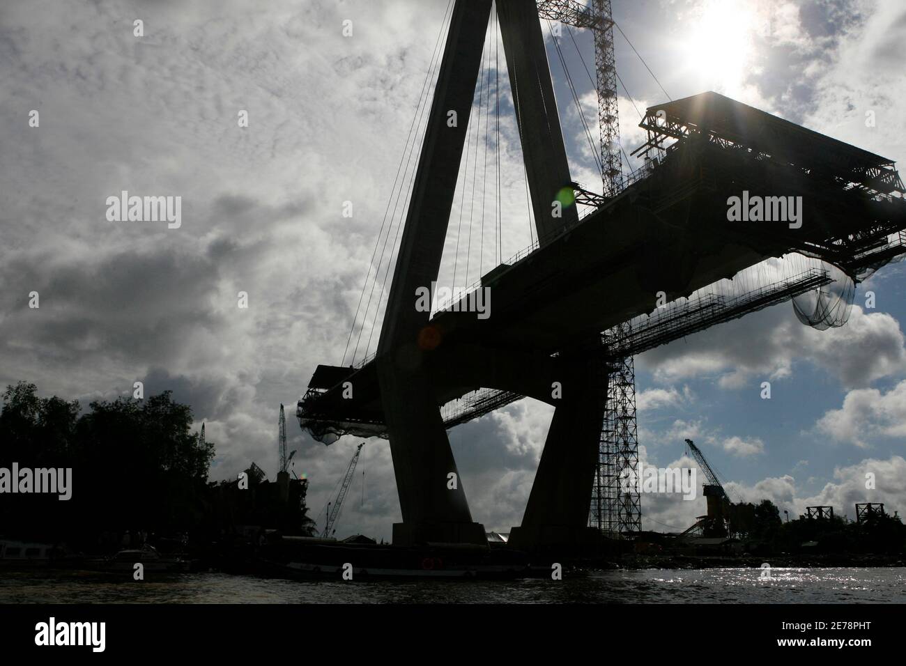A collapsed bridge is seen from Hau River in Vietnam's Mekong Delta's Vinh Long province September 27, 2007. Rescue workers found eight more bodies on Thursday in the rubble of a bridge which collapsed killing up to 60 people in Vietnam's worst such accident, officials said. Rescuers toiled through the night cutting away steel scaffolding and concrete in the Mekong Delta where a section of a Japanese-funded bridge under construction collapsed on Wednesday while 250 workers were on the site. REUTERS/Kham (VIETNAM) Stock Photo