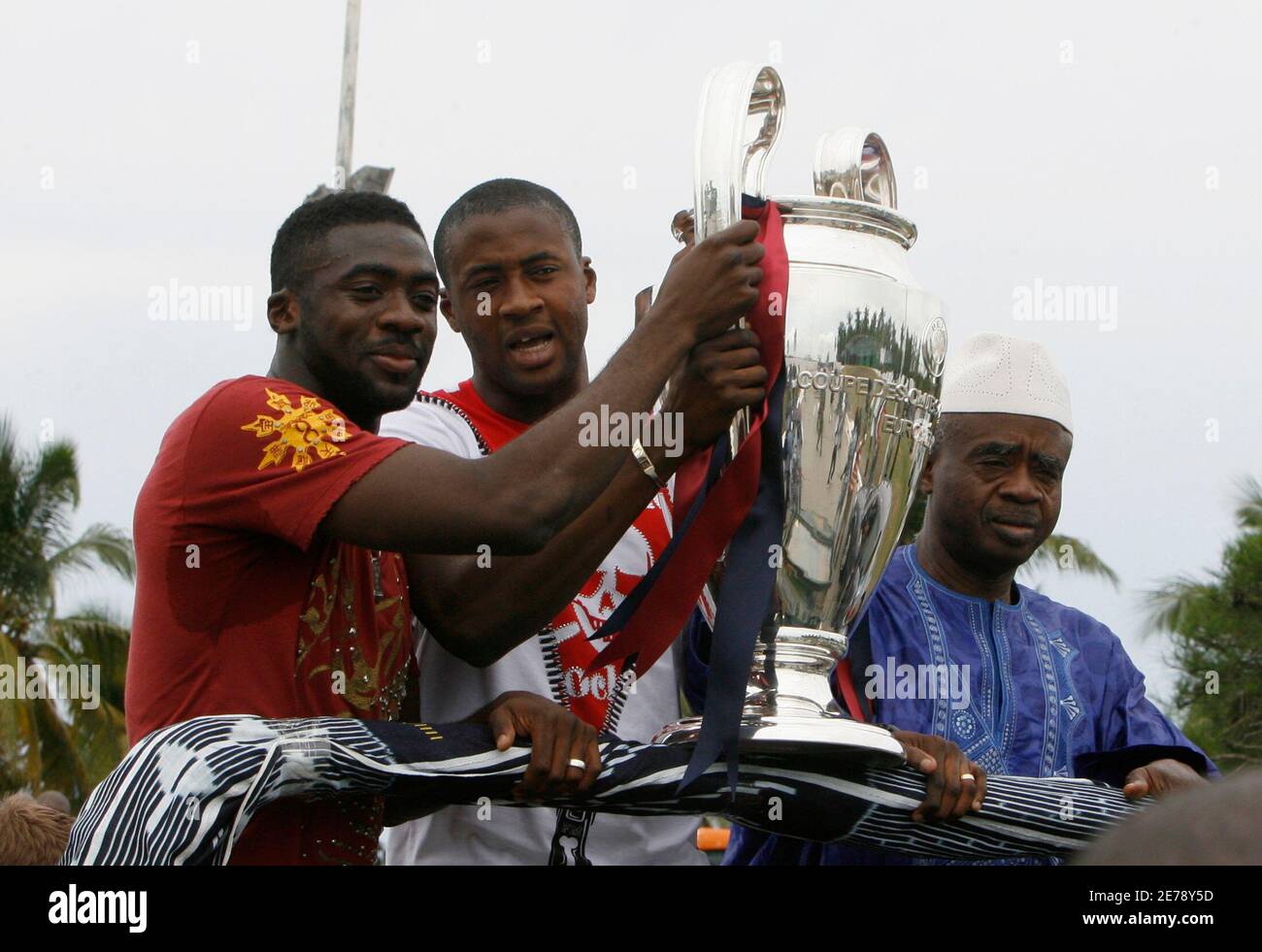 Barcelona's Yaya Toure (C) of the Ivory Coast holds the UEFA Champions  League trophy with his brother Arsenal's Kolo Toure in Abidjan June 1,  2009. At right is their father Mory Toure.