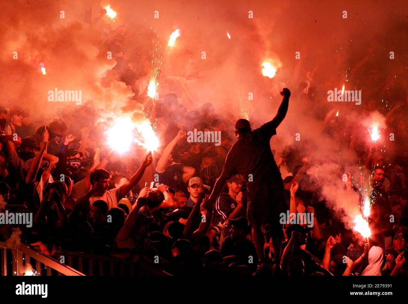 Fans of Croatian soccer club Dinamo Zagreb light flares and torches during local derby Hajduk Split in Zagreb.  Fans of Croatian soccer club Dinamo Zagreb, the 'Bad Blue Boys', light flares and torches in the stands during a match with archrivals Hajduk Split in Zagreb September 11, 2005. The high-risk derby, played amid fears of crowd trouble, was monitored by almost 1,000 policemen. REUTERS/Nikola Solic Stock Photo