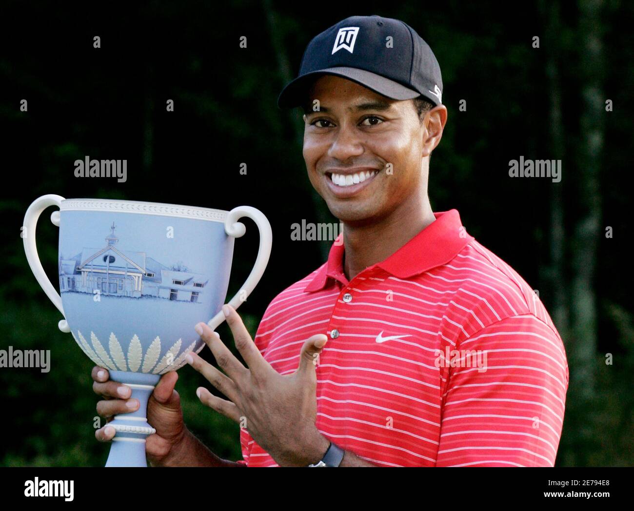 U.S. golfer Tiger Woods holds the tournament trophy after winning the 2006 Deutsche  Bank Championship golf tournament in Norton, Massachusetts September 4,  2006. Woods holds up five fingers to show his fifth