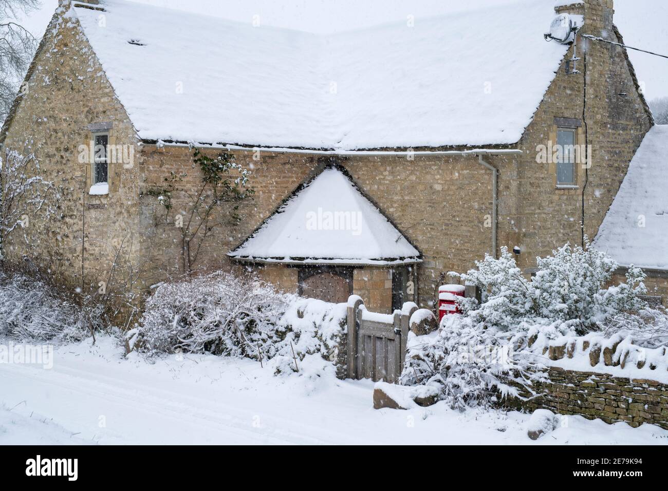 Cotswold stone cottage in Swinbrook in the snow. Swinbrook, Cotswolds, Oxfordshire, England Stock Photo