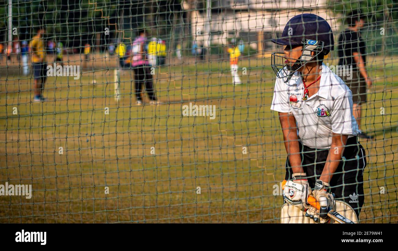 Mumbai, India - December 20, 2020: Unidentified boy practicing batting to improve cricketing skills at Mumbai ground Stock Photo