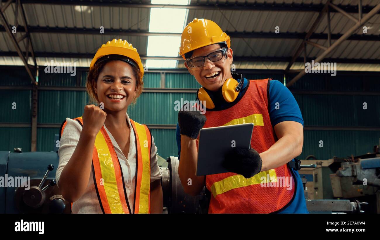 Two skillful factory engineer or worker happy portrait looking at camera . Industrial people and manufacturing labor concept . Stock Photo