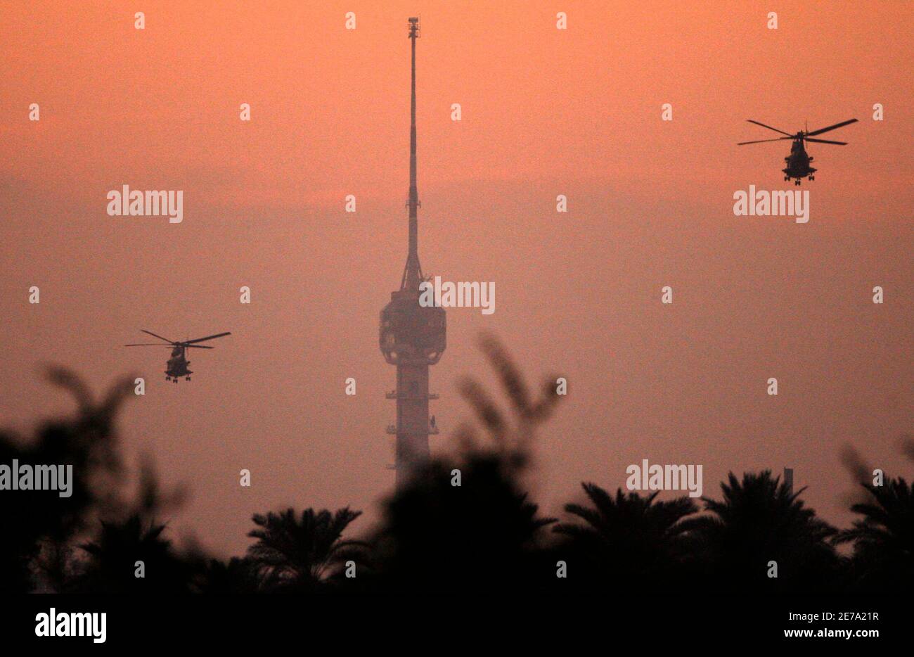 U.S. military helicopters patrol over Baghdad during sunset December 14, 2006. REUTERS/Nikola Solic (IRAQ) Stock Photo