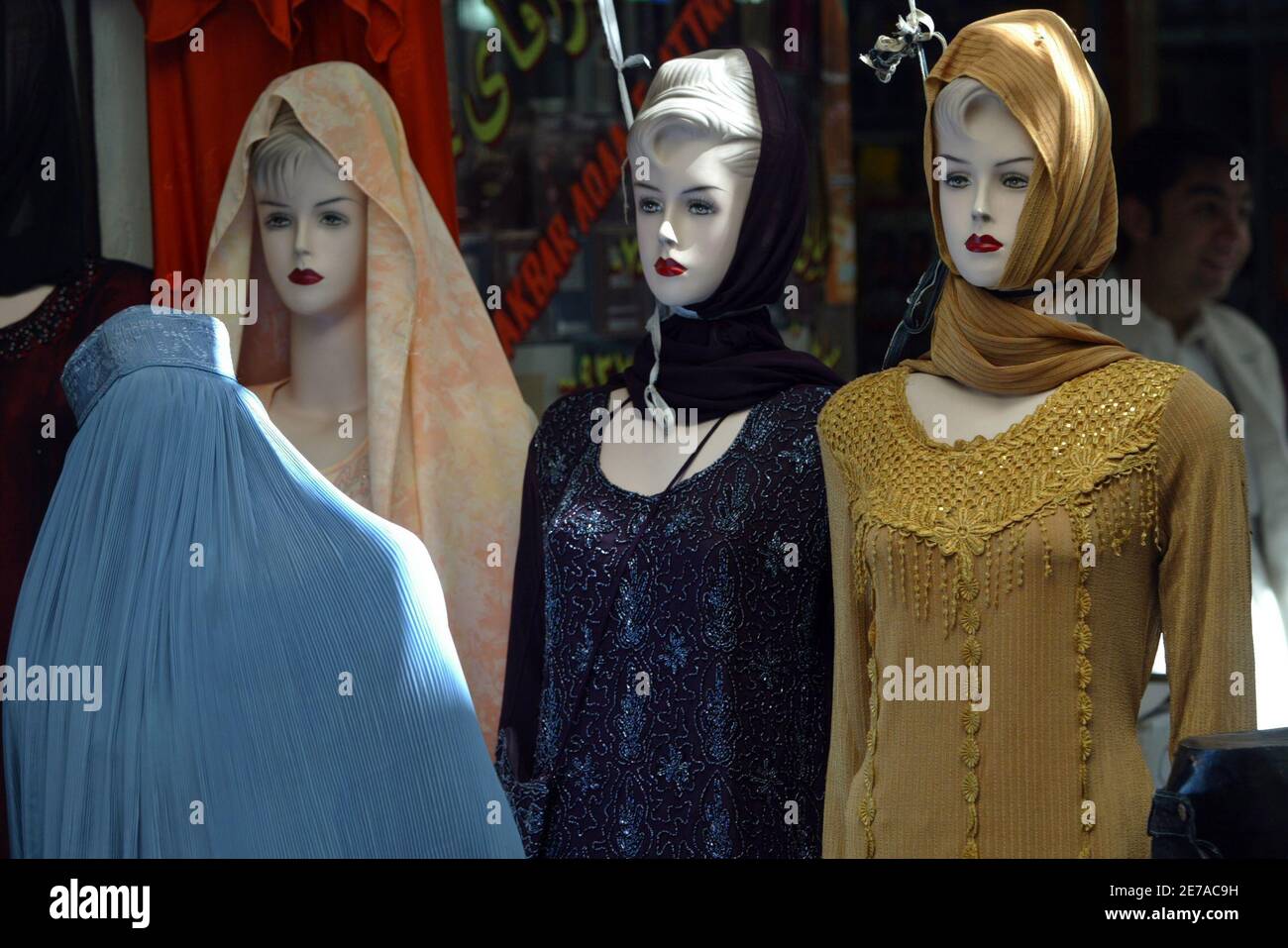 An Afghan woman looks at clothes on mannequins at a shop in Herat market September 23, 2005. The Taliban vowed on Wednesday to step up their holy war against foreign troops in Afghanistan and dismissed legislative polls held at the weekend as an American drama rejected by the Afghan people. REUTERS/Caren Firouz Stock Photo