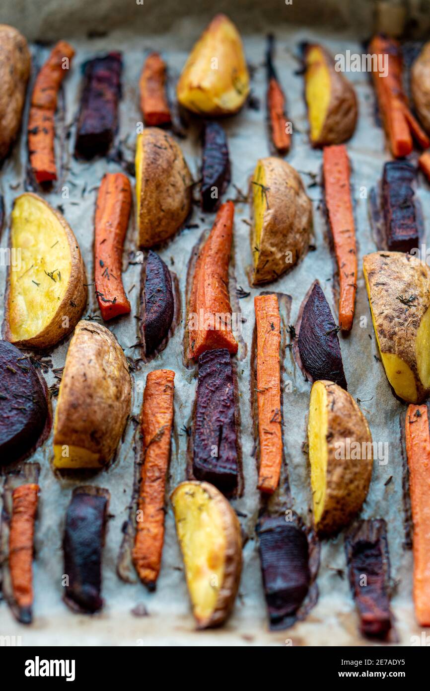 restaurant, vegetarianism, fast, healthy food, recipes concepts - Oven baked cut vegetables potatoes carrots, beets with seasoning dill. Roasted Stock Photo
