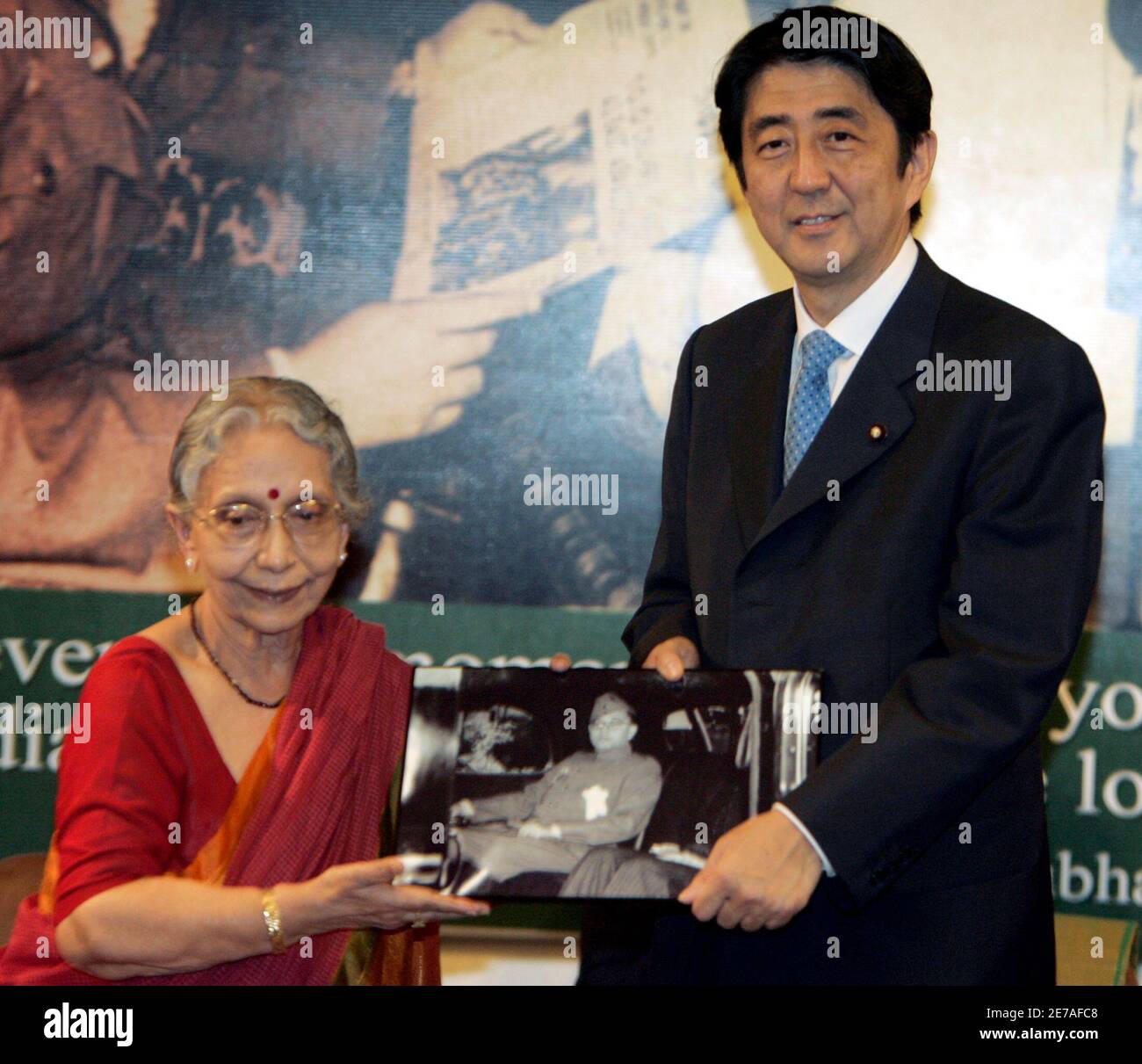 Japan's Prime Minister Shinzo Abe (R) is gifted a photograph of Indian  freedom fighter Netaji Subhas Chandra Bose by Krishna Bose, Chairperson of  Netaji Research Bureau, during his visit to the residence
