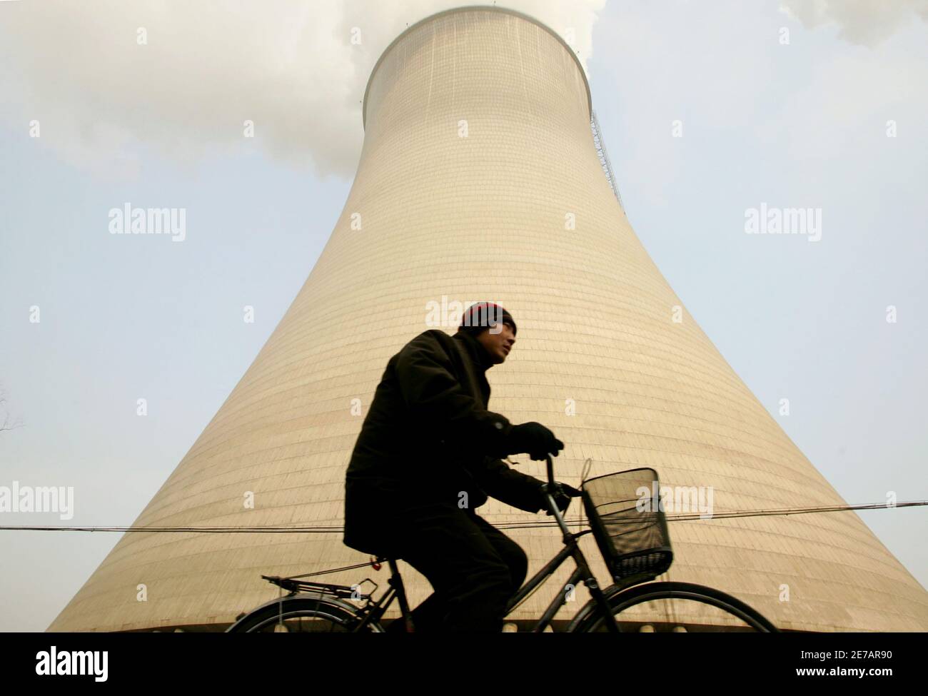A Chinese man cycles past a coal-run power plant after an [explosion] in Tangshan in China's Hebei province December 9, 2005. [A gas explosion at a Chinese coal pit has killed at least 74 miners, state media said on Thursday, notching up another statistic in a grimly predictable series in the world's deadliest mining industry.] Stock Photo