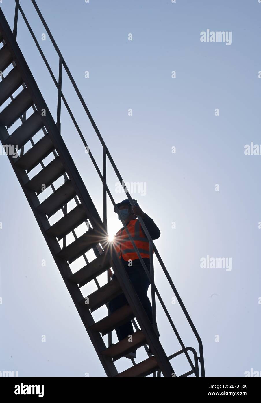 (210130) -- PUTIAN, Jan. 30, 2021 (Xinhua) -- Wang Ruifeng ascends the stairs to enter the operation room of the girder crane at a girder constructing field of the China Railway 11 Bureau Group Co., Ltd. in Putian City, southeast China's Fujian Province, Jan. 29, 2021. Wang Ruifeng, born in 1997, has been working as a girder crane operator for two years. Working high above the ground, Wang has to cooperate with ground workers to lift and move box girders weighing over 900 tonnes precisely to the specified location. Girder crane operators have become indispensable for high-speed railway constru Stock Photo