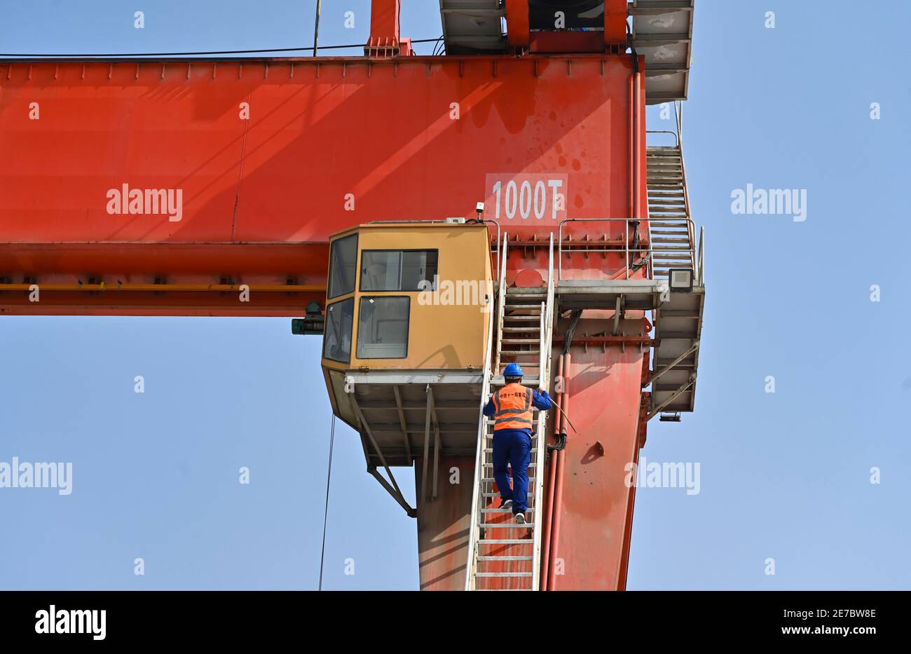 (210130) -- PUTIAN, Jan. 30, 2021 (Xinhua) -- Wang Ruifeng ascends the stairs to enter the operation room of the girder crane at a girder constructing field of the China Railway 11 Bureau Group Co., Ltd. in Putian City, southeast China's Fujian Province, Jan. 29, 2021. Wang Ruifeng, born in 1997, has been working as a girder crane operator for two years. Working high above the ground, Wang has to cooperate with ground workers to lift and move box girders weighing over 900 tonnes precisely to the specified location. Girder crane operators have become indispensable for high-speed railway constru Stock Photo