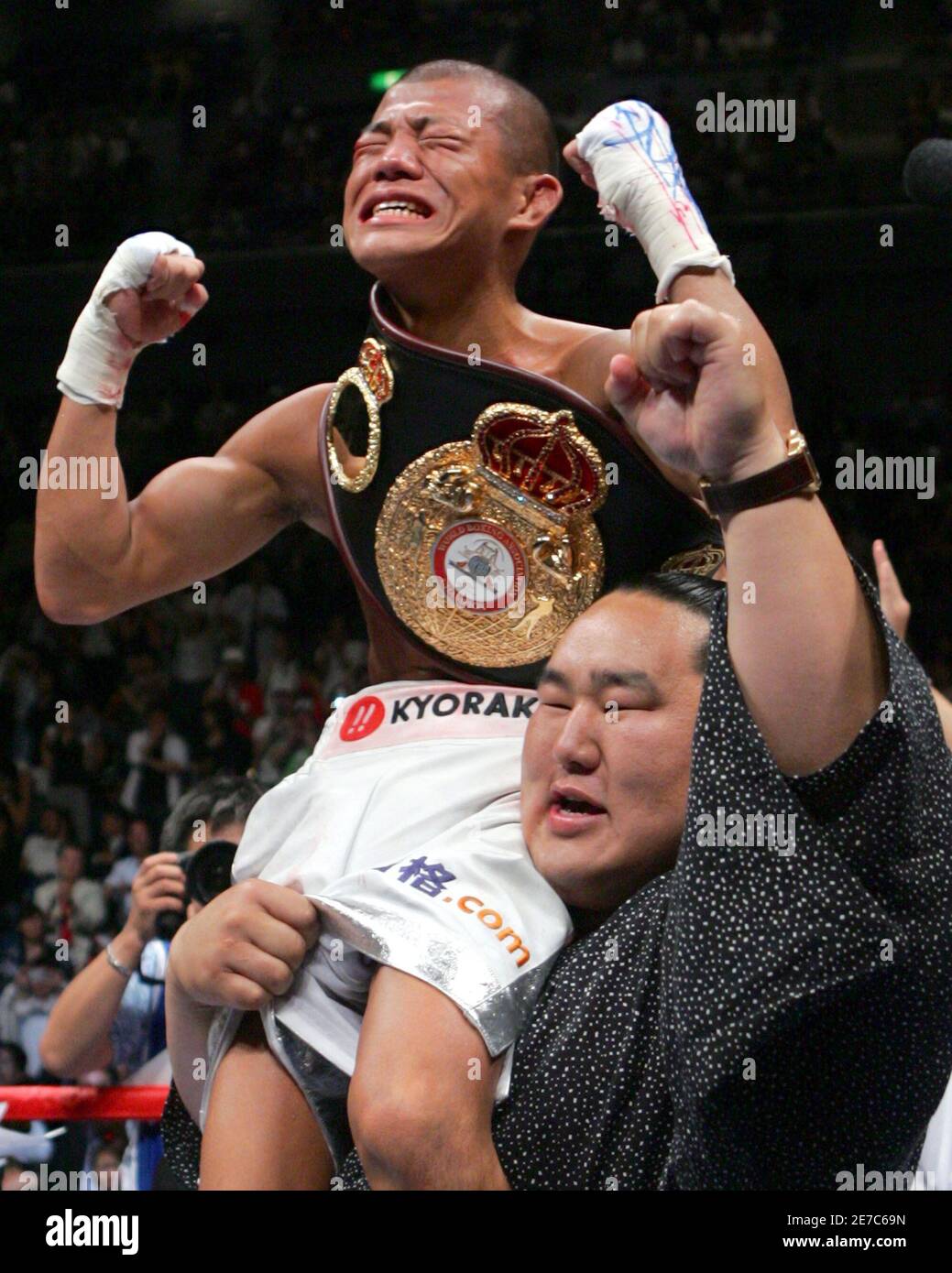 World Boxing Association (WBA) light flyweight new champion Koki Kameda  (top) of Japan is lifted by sumo grand champion yokozuna Asashoryu after  defeating Juan Jose Landaeta of Venezuela during their title bout