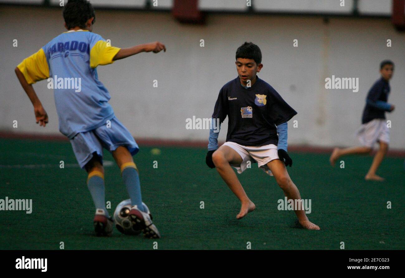 Young boy (R) from soccer academy "Academie Paradou"is challenged by Paradou  AC player during their friendly soccer match at Hydra stadium in Algiers  November 6, 2009. The Paradou/Jean Marc Guillou Academy selects
