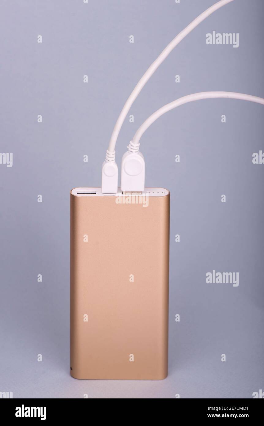Smartphone charging with power bank on a blue background Stock Photo