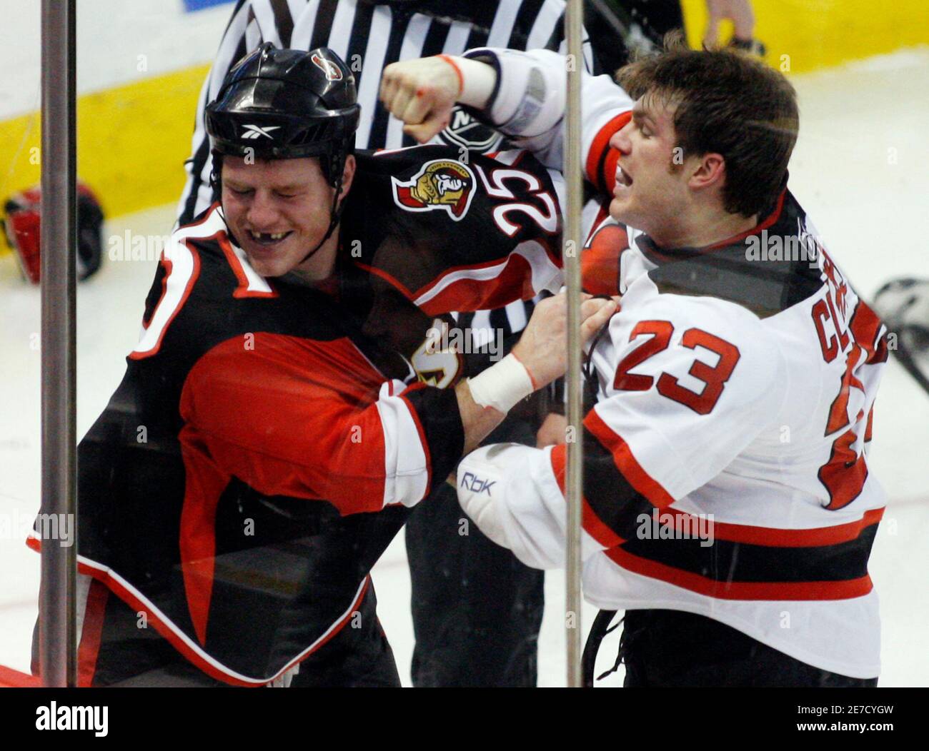 Ottawa Senators' Chris Neil (L) reacts as New Jersey Devils' David Clarkson  swings a fist at his head during the third period of their NHL hockey game  in Ottawa January 27, 2009.