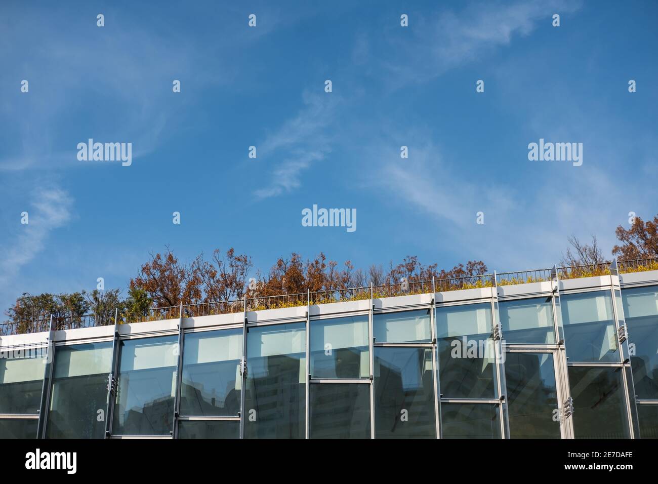 Modern glass facade office building against blue sky Stock Photo - Alamy