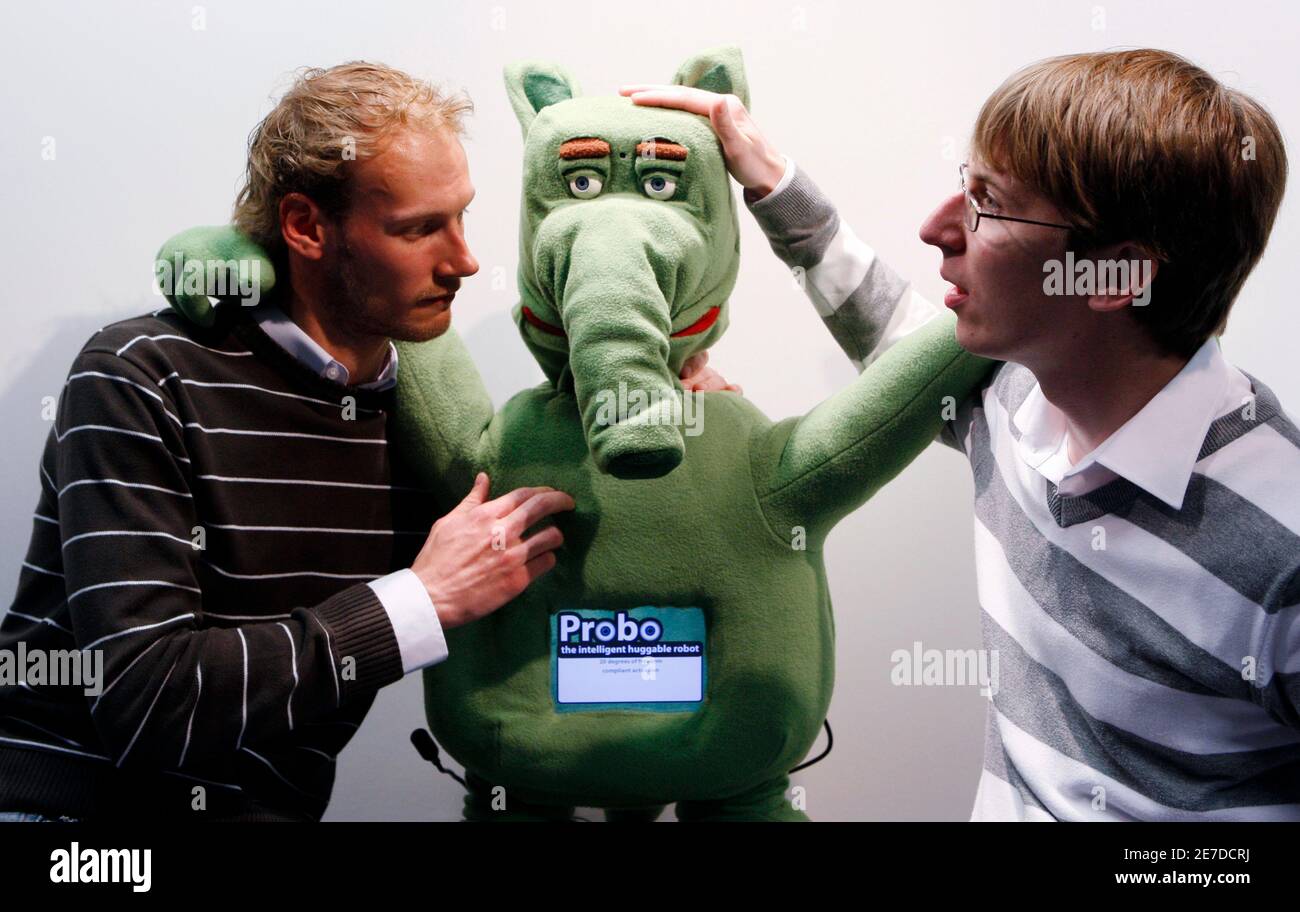 Belgian researchers Jelle Saldien and Kristof Goris (R) pose with Probo, the "huggable" robot, at the unveiling of the prototype in April 21, 2009. was designed to interact