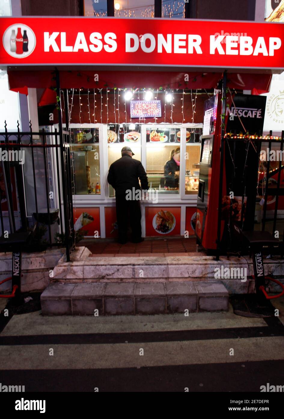 A man waits for his order in front of a kebab fast-food outlet in Bucharest  January 7, 2010. Recession-hit Romania plans to introduce a tax on fast-food  products to boost budget revenues,
