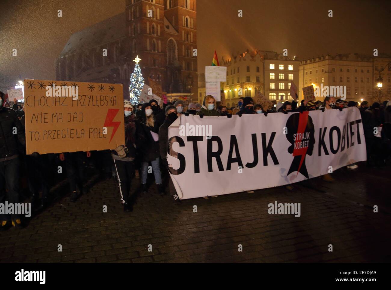 Crowd of people demonstrate with banners against decision to almost total ban barortion in Poland, Krakow evening snowy street, women strike movement Stock Photo