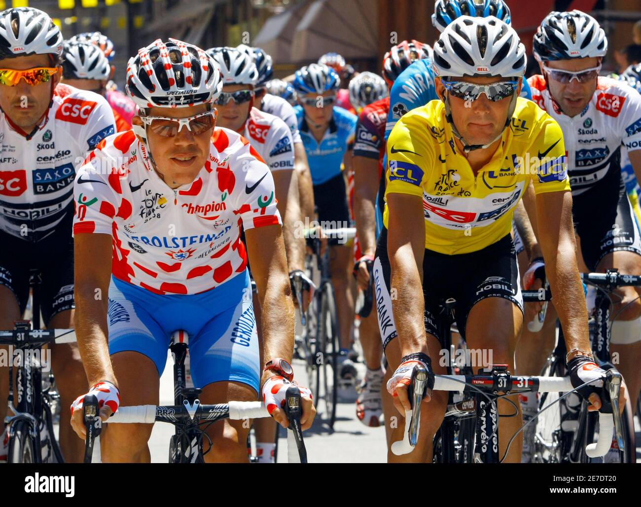 Team CSC Saxo Bank rider and leader's yellow jersey Frank Schleck of  Luxembourg (R) cycles with Gerolsteiner rider and climber's spotted jersey  Bernhard Kohl of Austria at the start of the 16th