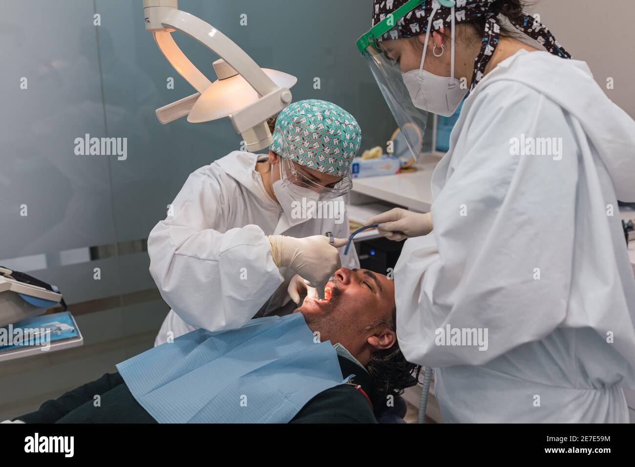Dental surgeon injecting anesthesia in the mouth. Three people. Dental