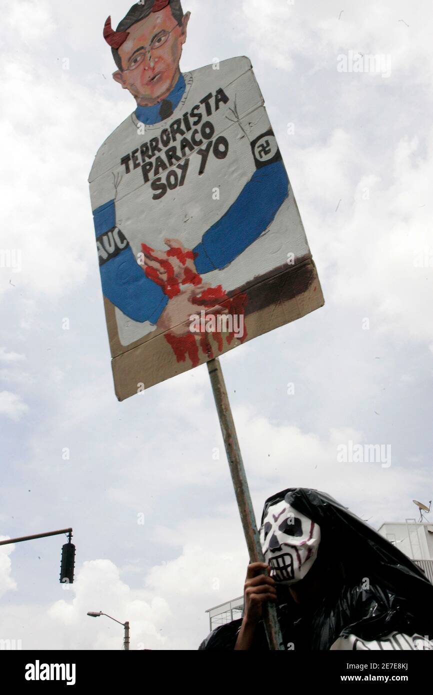 A masked demonstrator holds a banner with a image of Colombia's President Alvaro Uribe during a march against paramilitary violence in Bogota March 6, 2008. Thousands of Colombians headed for the streets on Thursday to protest against paramilitary right wing violence. The banner reads 'Terrorist, Paramilitary, I am'.      REUTERS/Carlos Duran(COLOMBIA) Stock Photo