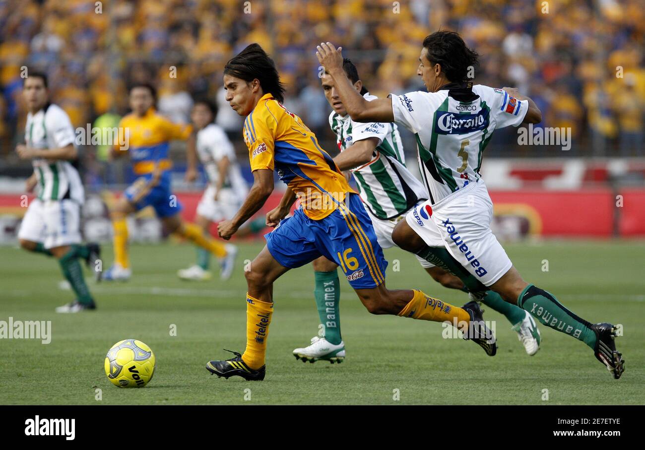 Tigres' Lucas Lobos (L) drives the ball past Santos' Fernando Arce (R) and  Juan Pablo Rodriguez during their Mexican league championship soccer match  at the Universitario stadium in Monterrey, northern Mexico April
