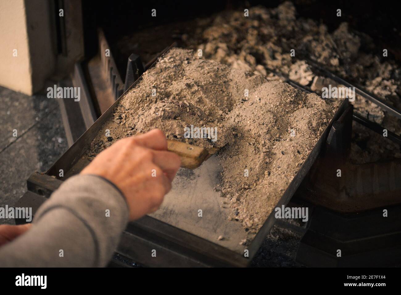A man cleaning ashes in the fireplace tray Stock Photo Alamy