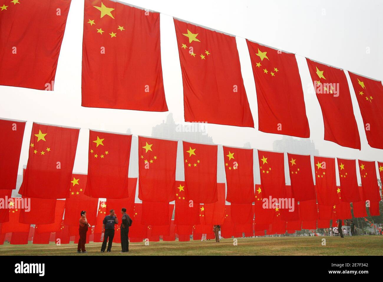 Visitors chat amidst Chinese national flags displayed at a park to celebrate National Day in Beijing October 6, 2006.  China is celebrating a week-long National Day holiday or 'Golden Week' holiday, which runs from October 1 to 7.       REUTERS/Claro Cortes IV    (CHINA) Stock Photo