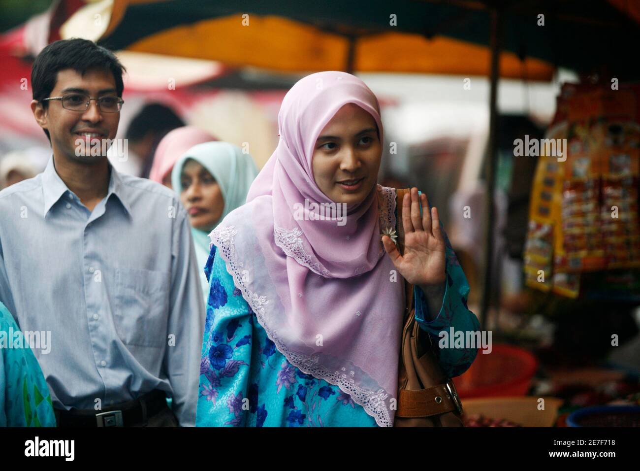 Malaysia S Opposition National Justice Party Candidate Nurul Izzah Anwar R Followed By Husband Raja Ahmad Shahrir Iskandar Waves As She Campaigns For The Upcoming Elections At A Market In Kuala Lumpur February