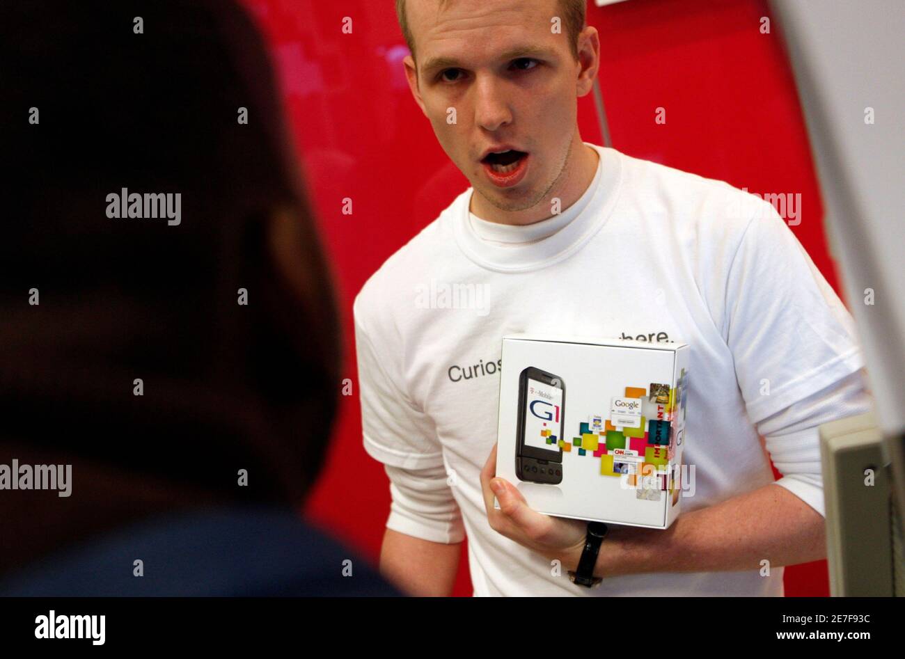 A T-Mobile employee holds the new G1 mobile telephone box as he speaks with a customer at a T-Mobile store in New York City, October 22, 2008.  REUTERS/Mike Segar  (UNITED STATES) Stock Photo