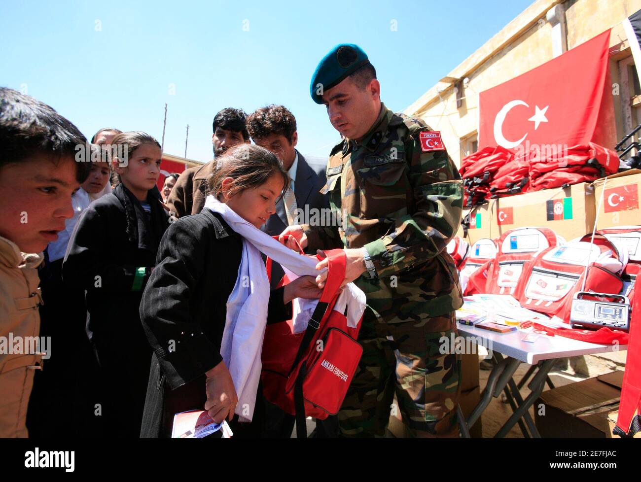 Afghan school children line up as a Turkish army officer delivers school  material during a donation campaign in Bagrami district in Kabul April 5,  2007. Turkish task force is expected to take