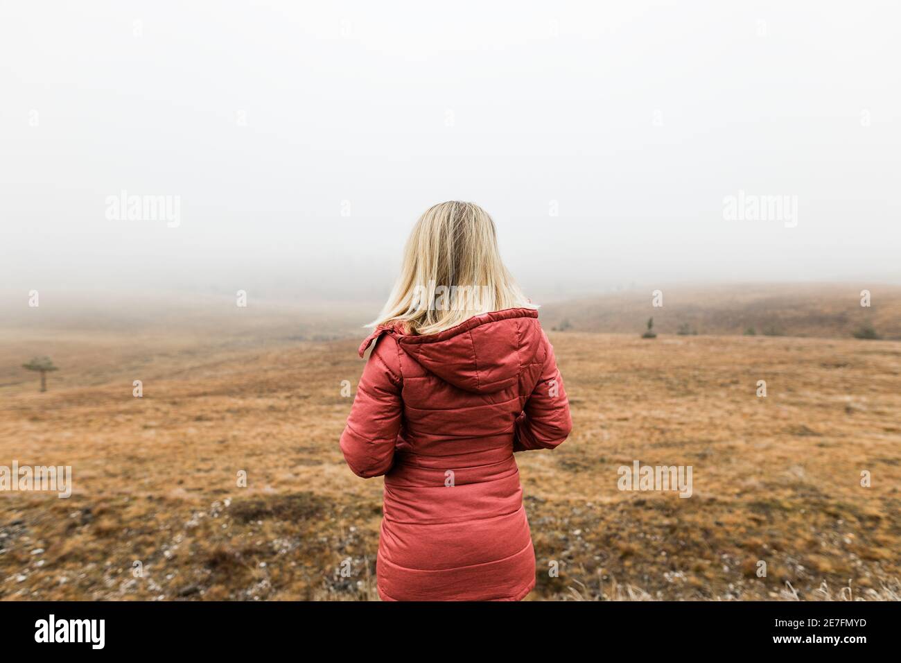 Young woman exploring nature in the foggy winter morning Stock Photo