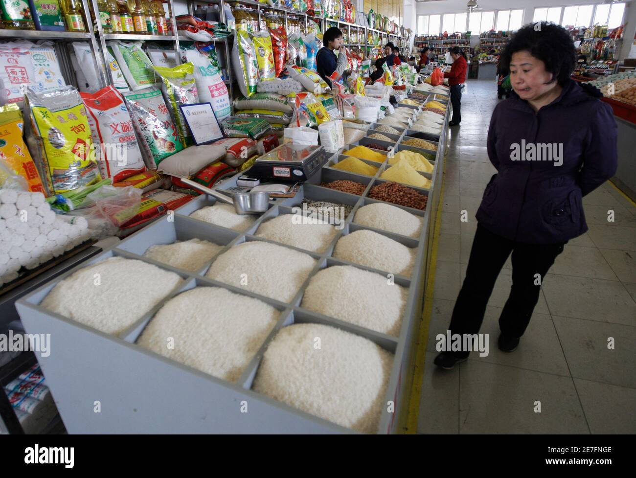 A woman looks at rice at a market in Beijing April 3, 2008. World rice production is set to increase by 1.8 percent this year as government incentives and high prices spur output in Asia and Africa, the United Nations Food and Agriculture Organisation (FAO) said on Wednesday. REUTERS/Jason Lee (CHINA) Stock Photo