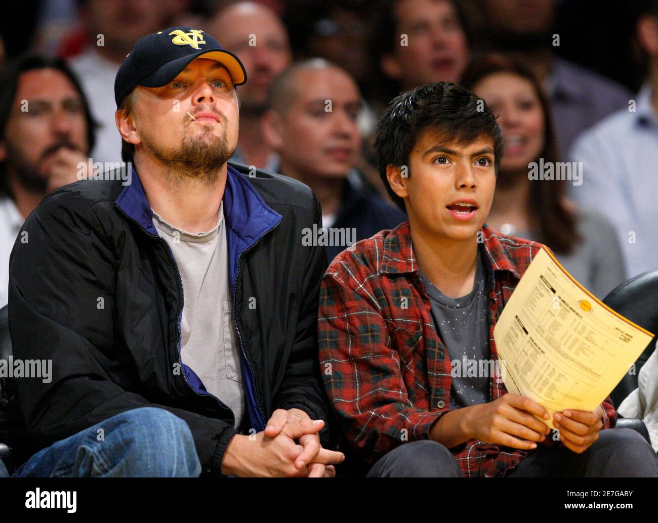 Actor Leonardo DiCaprio (L) sits next to an unidentified youth as they  watch the Los Angeles Lakers play the Utah Jazz during their NBA basketball  game in Los Angeles April 14, 2009.