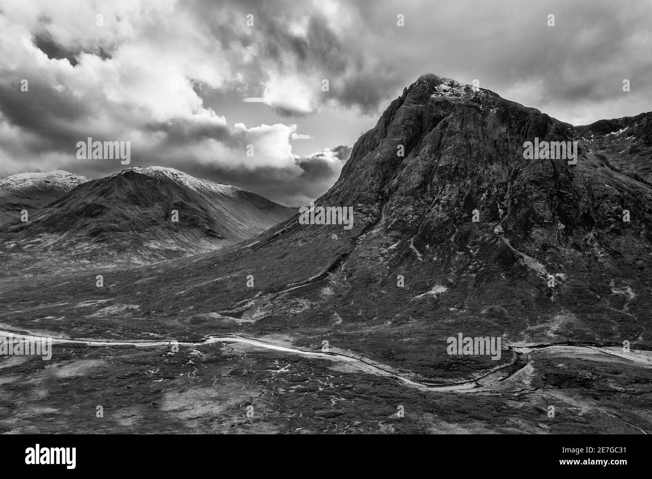 Flying drone dramatic  black and white landscape image of Buachaille Etive Mor and surrounding mountains and valleys in Scottish Highlands on a Winter Stock Photo