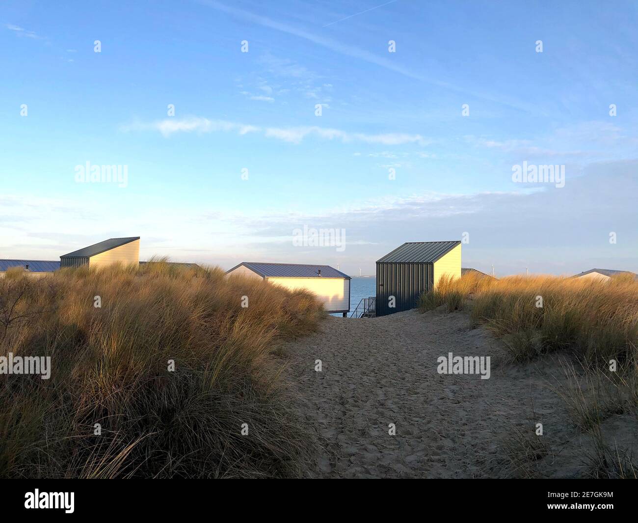 Small modern houses built on a sand land next to a sea under the clear ...