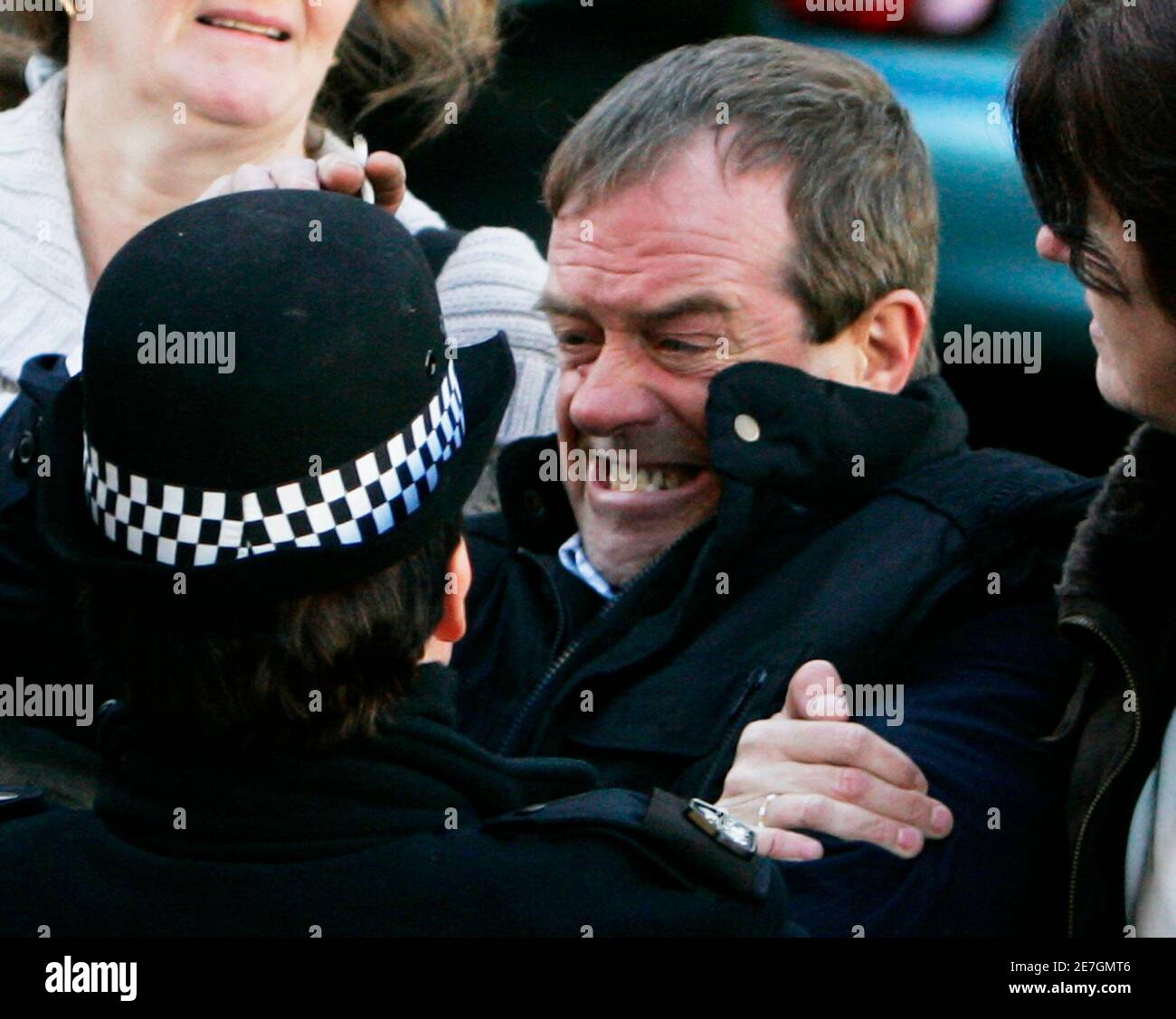 Michael Hamilton, the father of missing girl Vicky Hamilton, is restrained by friends and a police officer after he tried to attack the prison van carrying Peter Tobin, who is accused of killing Vicky, outside Linlithgow Sherriff Court, central Scotland November 15, 2007.  Tobin appeared in court on Thursday charged with murdering the teenage girl whose remains were found in a house in Kent, 16 years after she vanished from her home.      REUTERS/David Moir (BRITAIN) Stock Photo