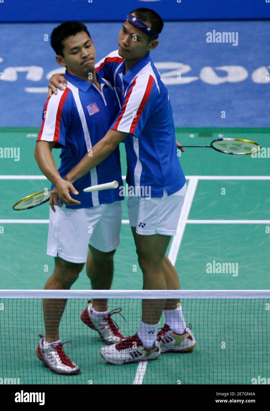 Bob Malaythong of the U.S. (R) hugs his teammate Howard Bach after losing  the men's doubles quarter-final badminton match against Cai Yun and Fu  Haifeng of China at the Beijing 2008 Olympic